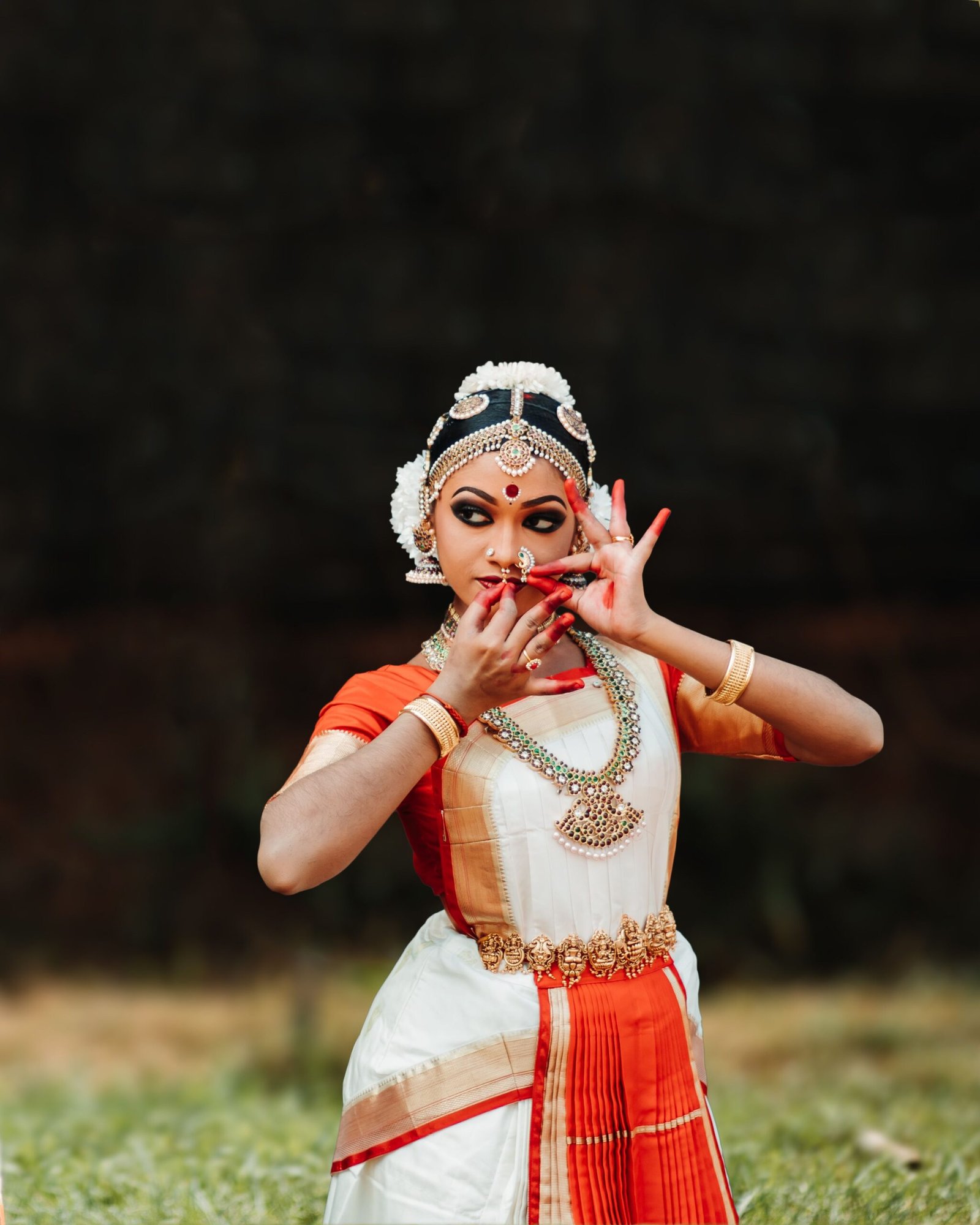A female dancer in traditional Kerala attire, showcasing cultural dance pose in India.